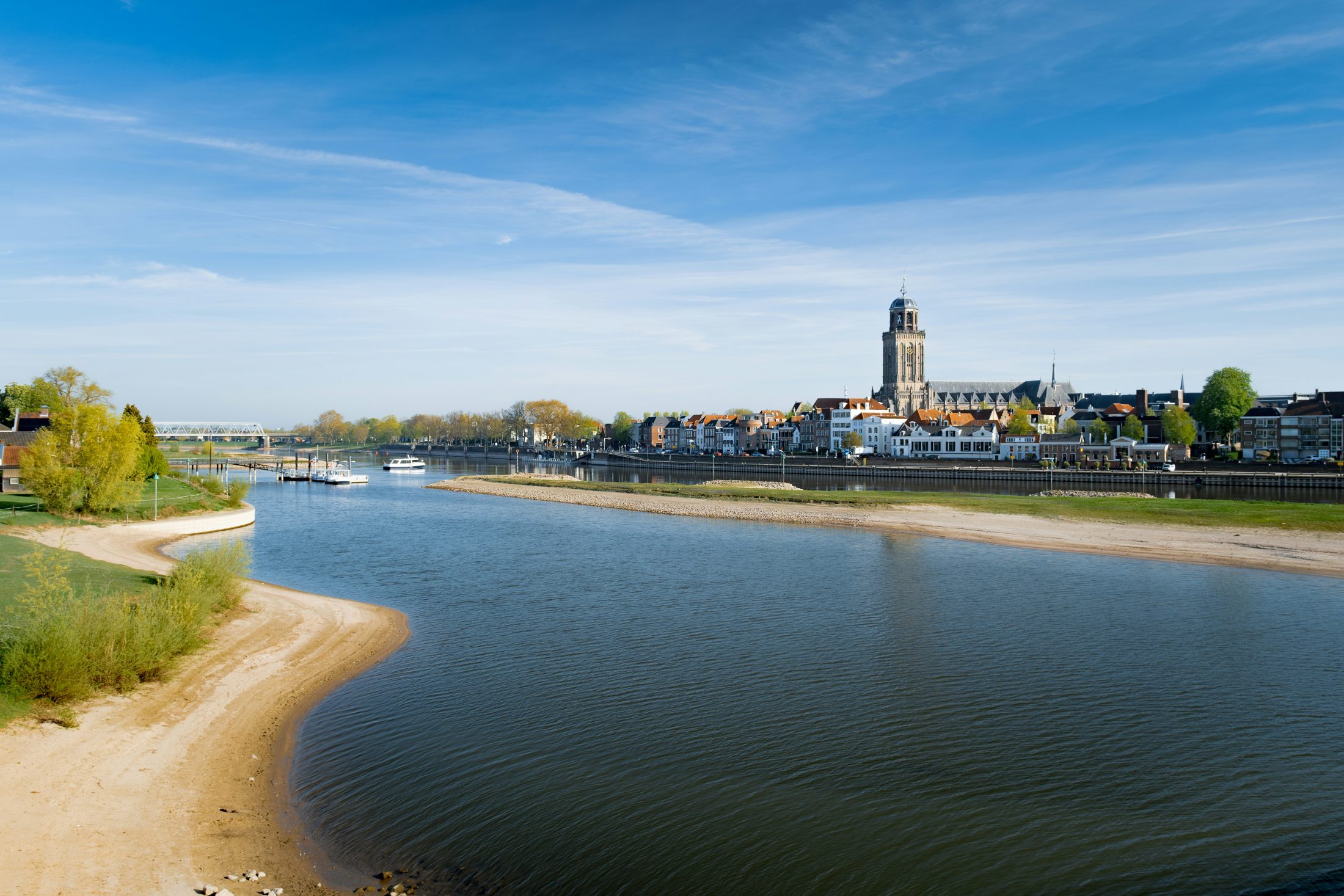 Een Nederlandse rivierstad aan de IJssel onder een blauwe hemel